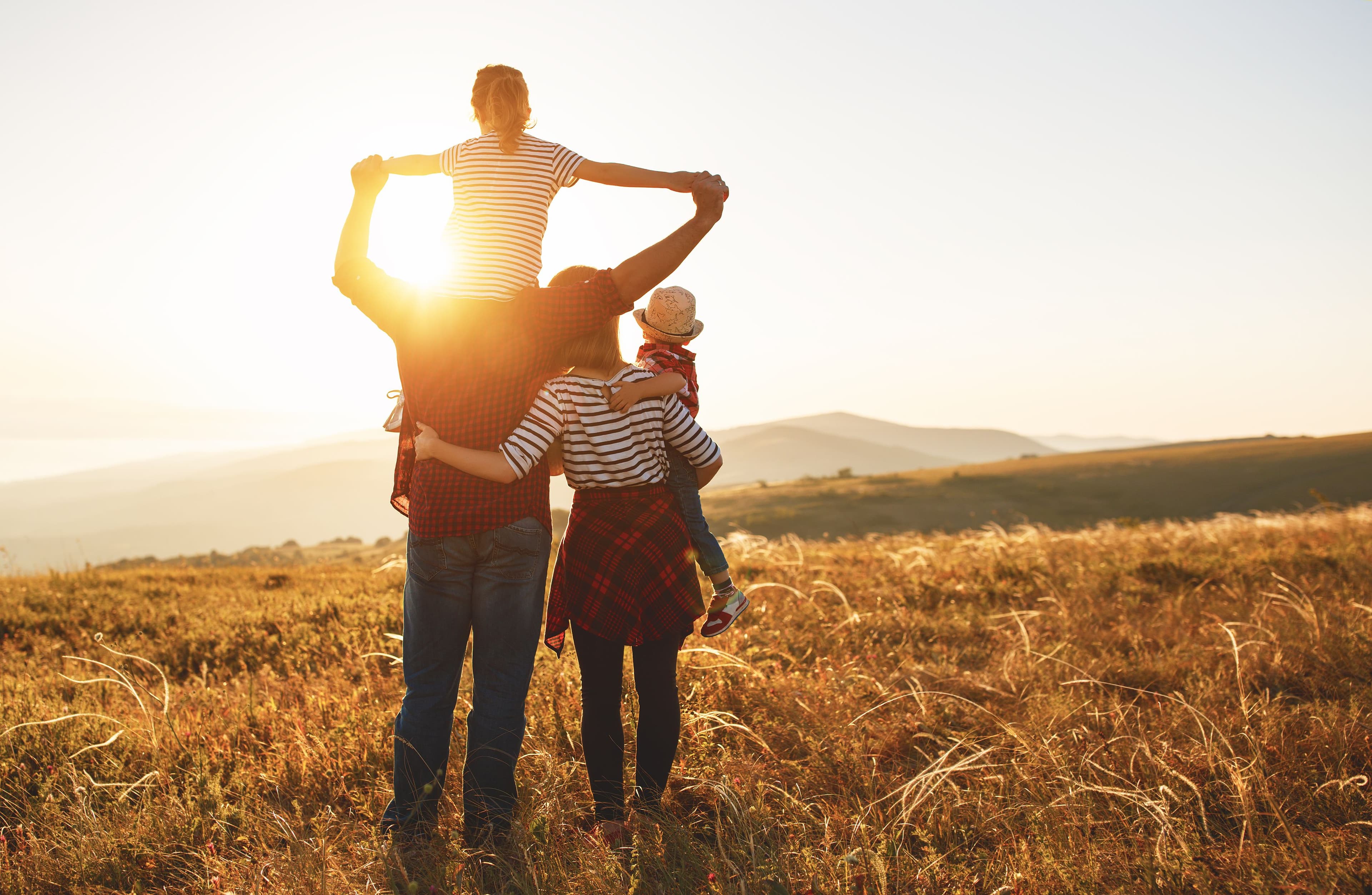 En familie som står og ser utover en fantastisk utsikt etter å ha tatt forbrukslån til ferie.