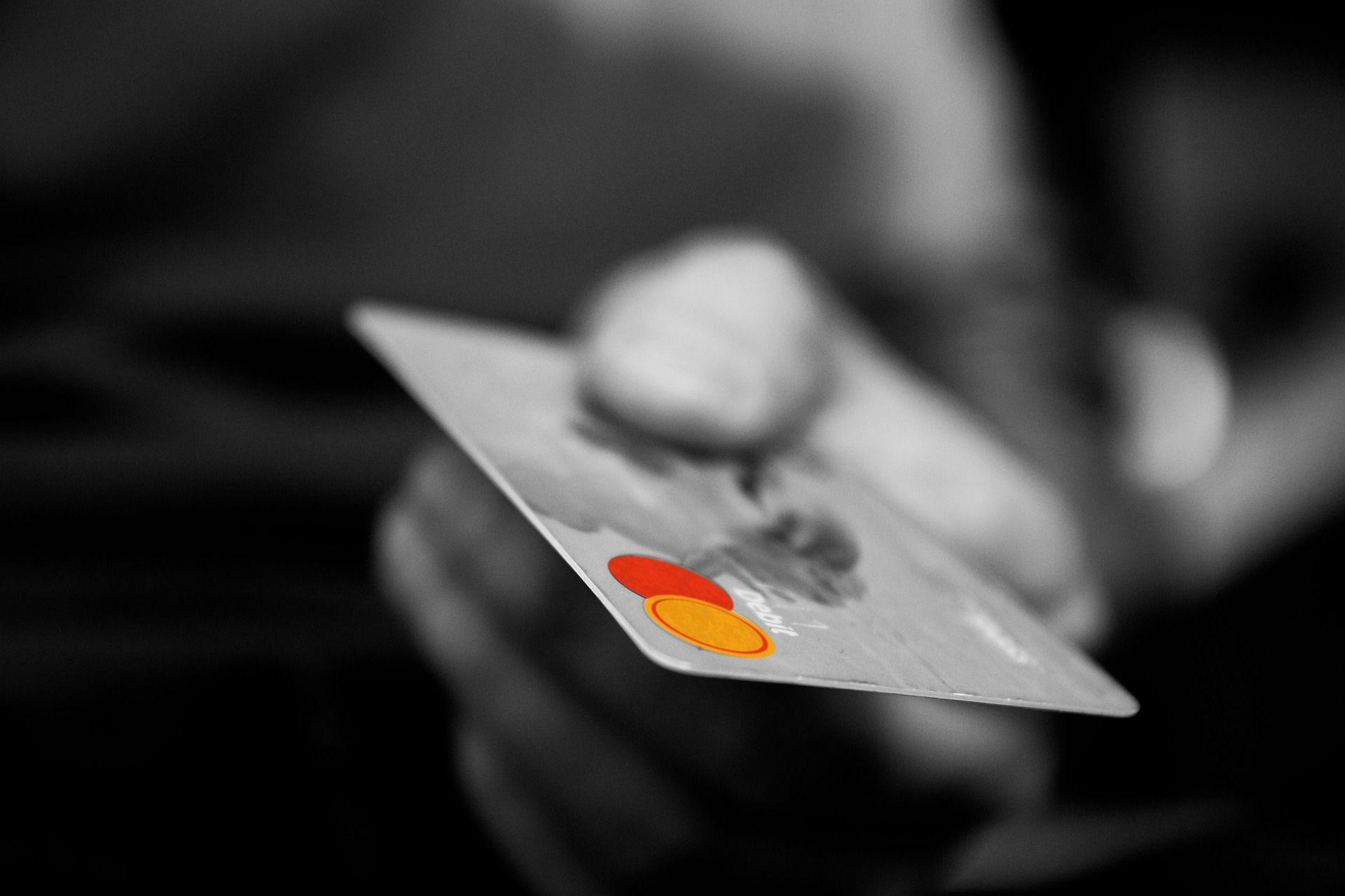 En hånd som holder et kredittkort, og mannen som holder det har fått laveste rente på kredittkort.