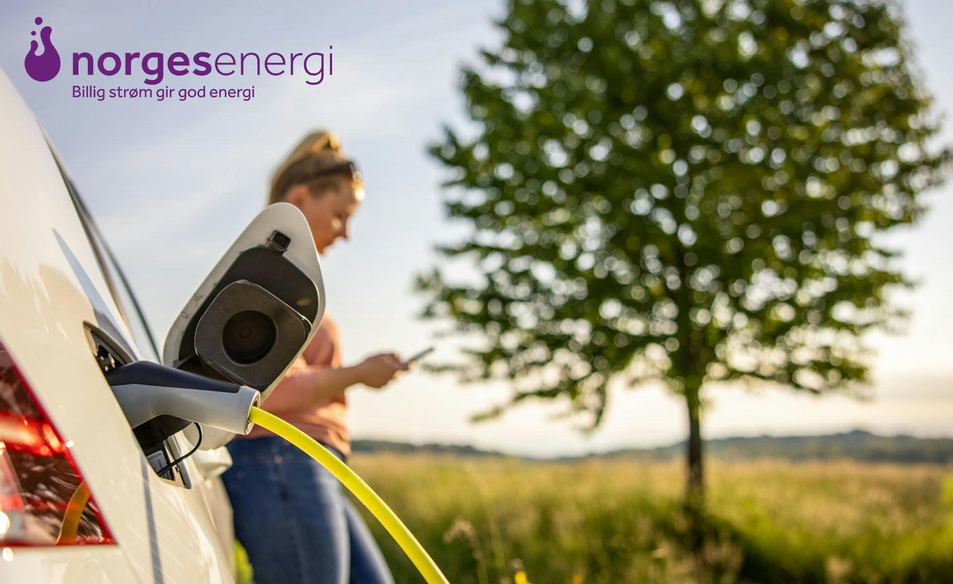 Ei dame som står med bilen sin og bruker NorgesEnergi mobilabonnement og strøm.